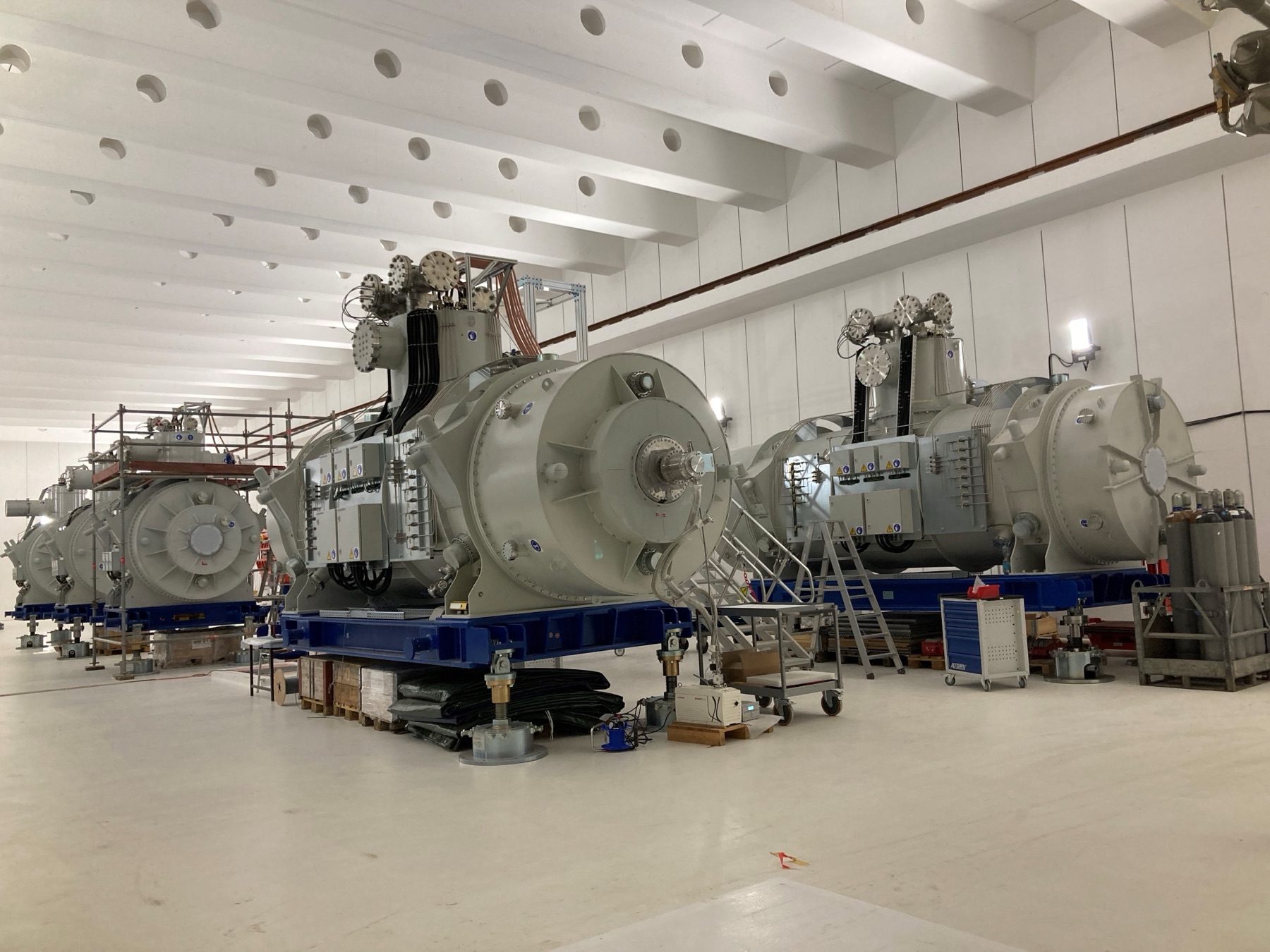 Super-FRS superconducting multiplets with hermetic feedthroughs on the cryostat turrets, under assembly for the FAIR project